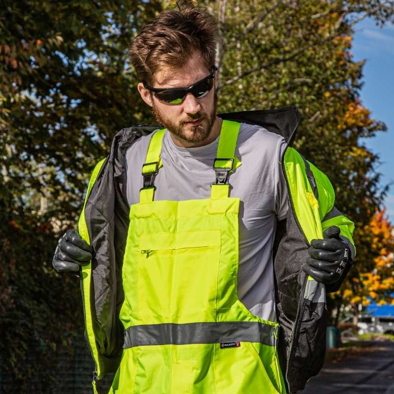 Worker putting on a high visibility jacket outdoors